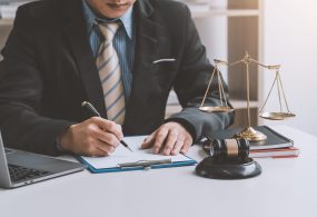 Close-up of businessman and lawyer hand holding pen to taking notes at office.